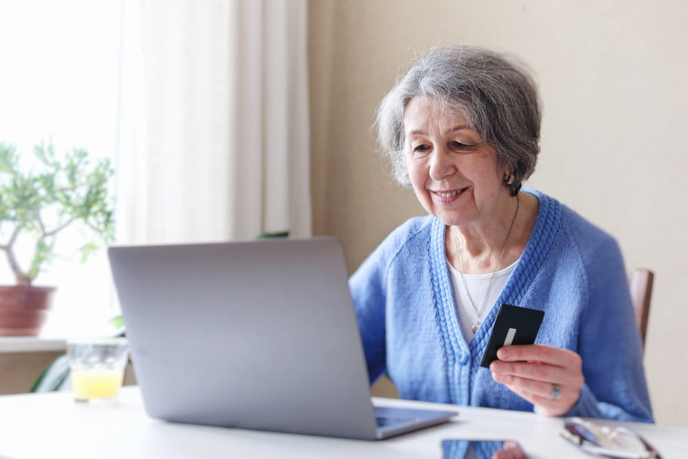 An eldelry woman smiling at a successful online donation showing the importance of accessibility for non‑profit websites